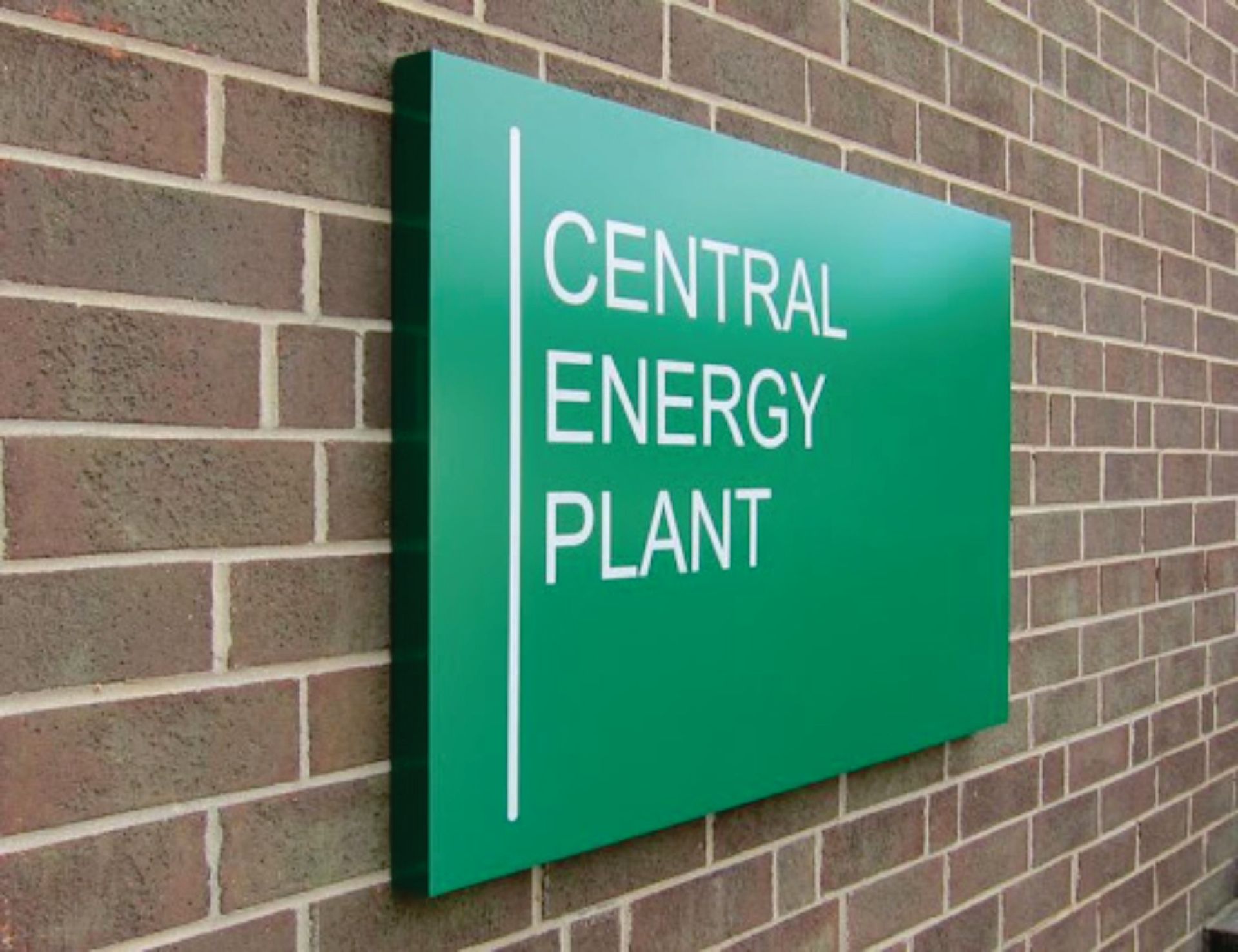 Green sign on a brick wall: 