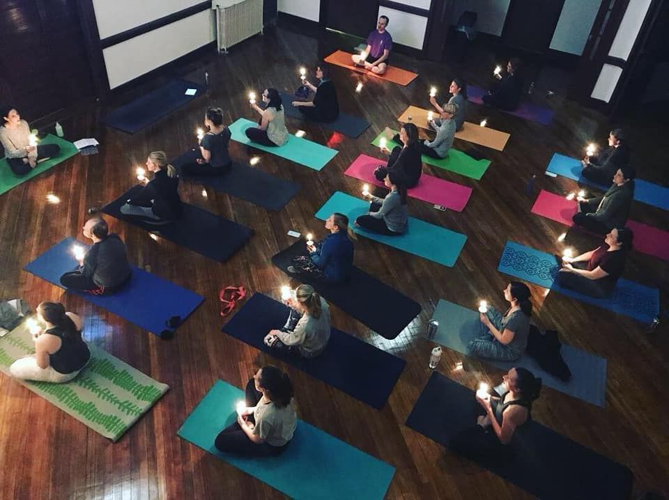 YoWo (yoga+worship) at Short North Church. People seated on colorful yoga mats in a studio, practicing meditation in a circle