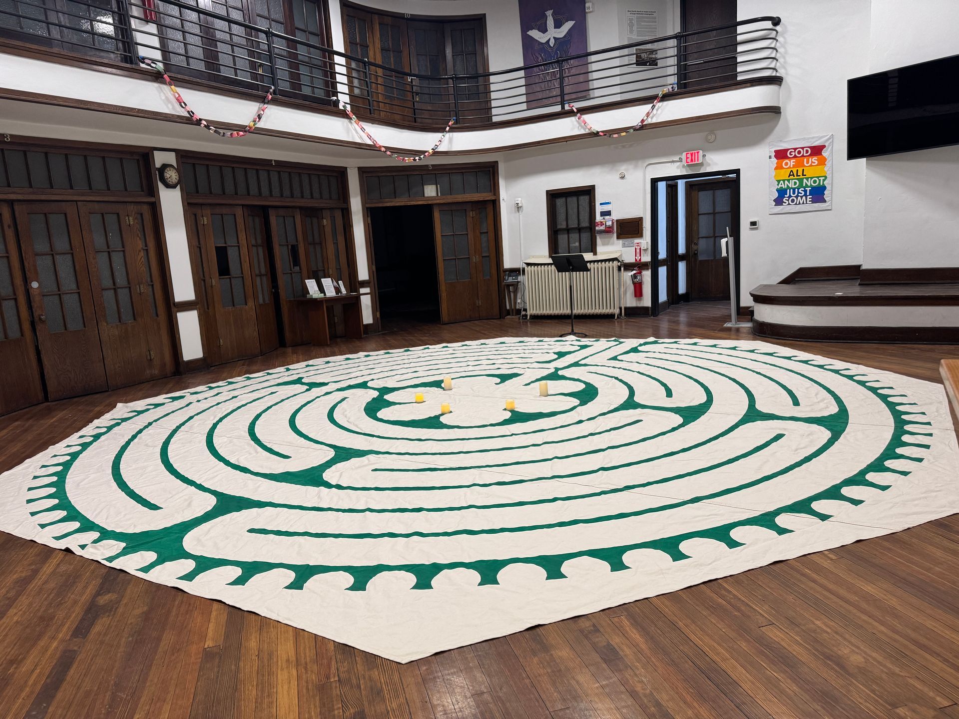 Short North Church. Interior hall with a large green-and-white circular floor mural and wooden railings around the balcony.