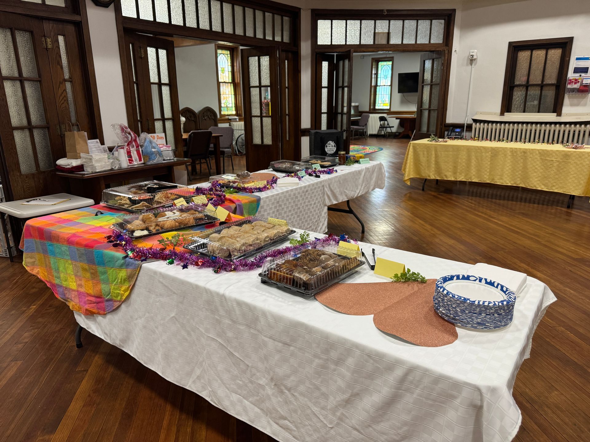 Short North Church. Tables of colorful crafts and items displayed in a wood-floored room with large windows.