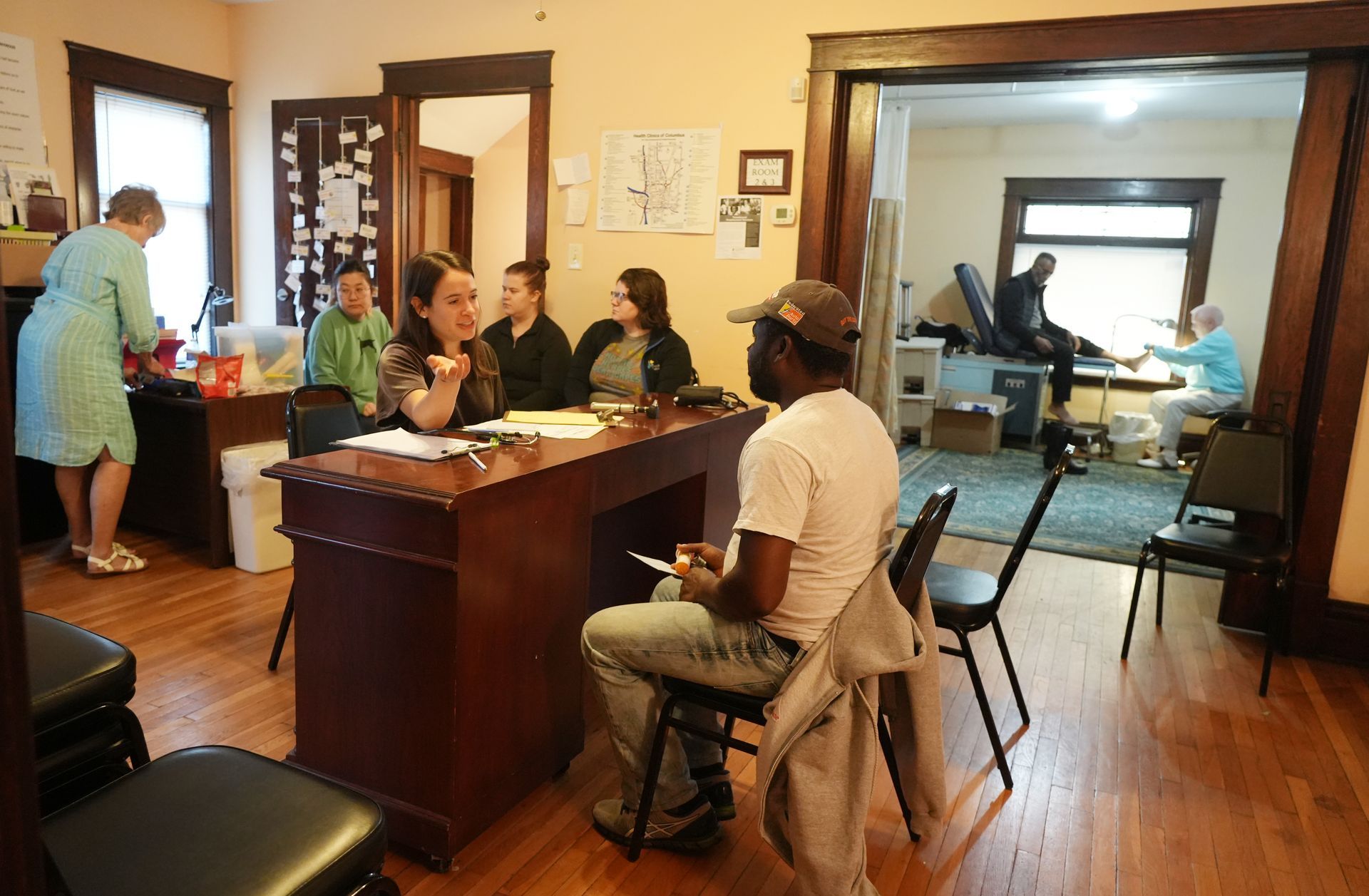 Short North Church. People meeting in a warmly lit office around a wooden table, with a reception area and hallway in the background