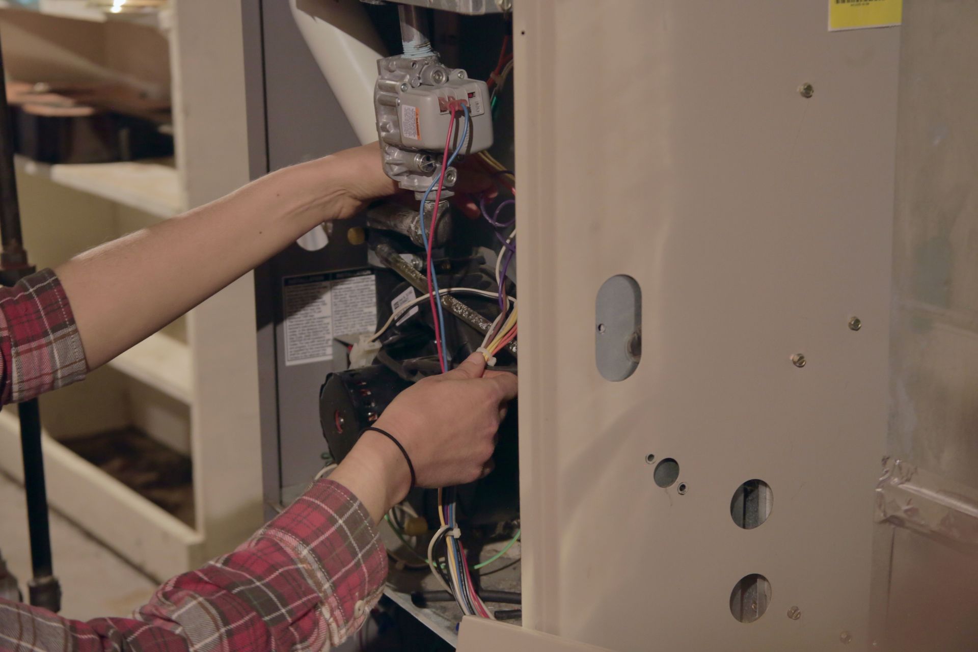Professional HVAC technician repairing a residential furnace system.