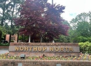 Sign for Northup North apartment complex. The sign is brown, with gold lettering and flowers.