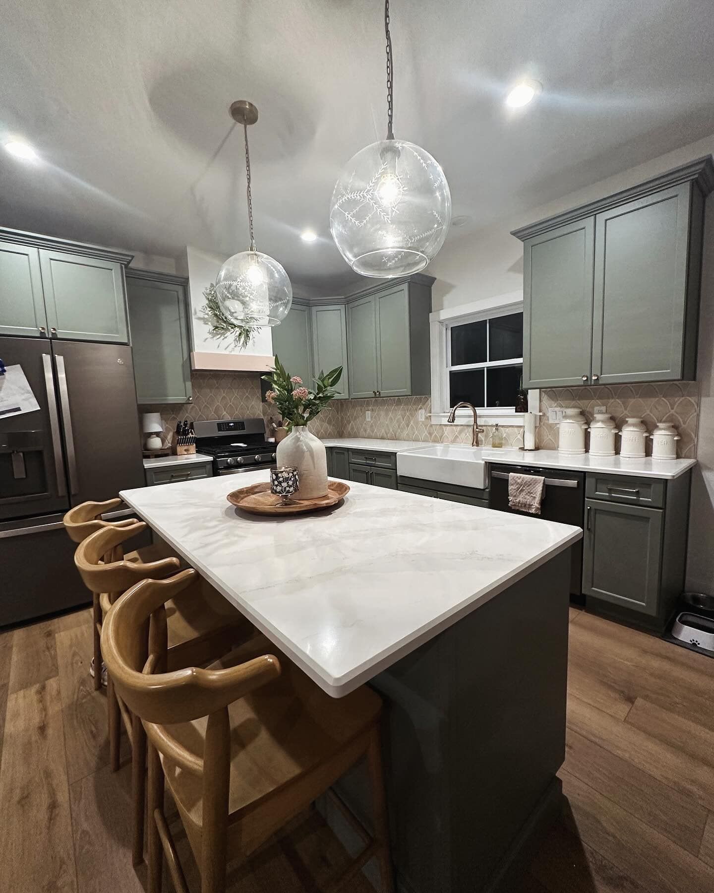 A kitchen with a large island and a marble counter top.