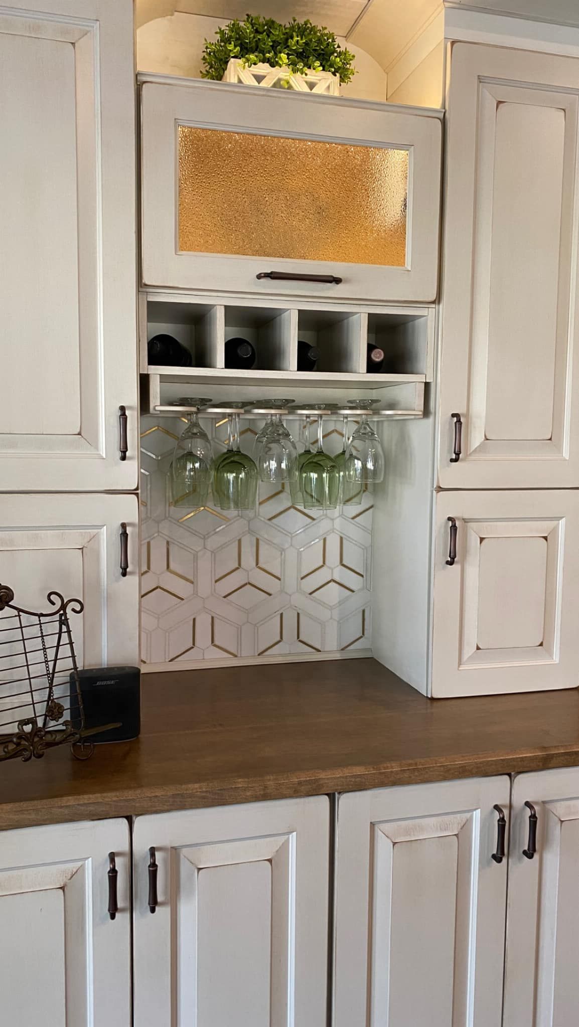 A kitchen with white cabinets and a wine rack on the wall.