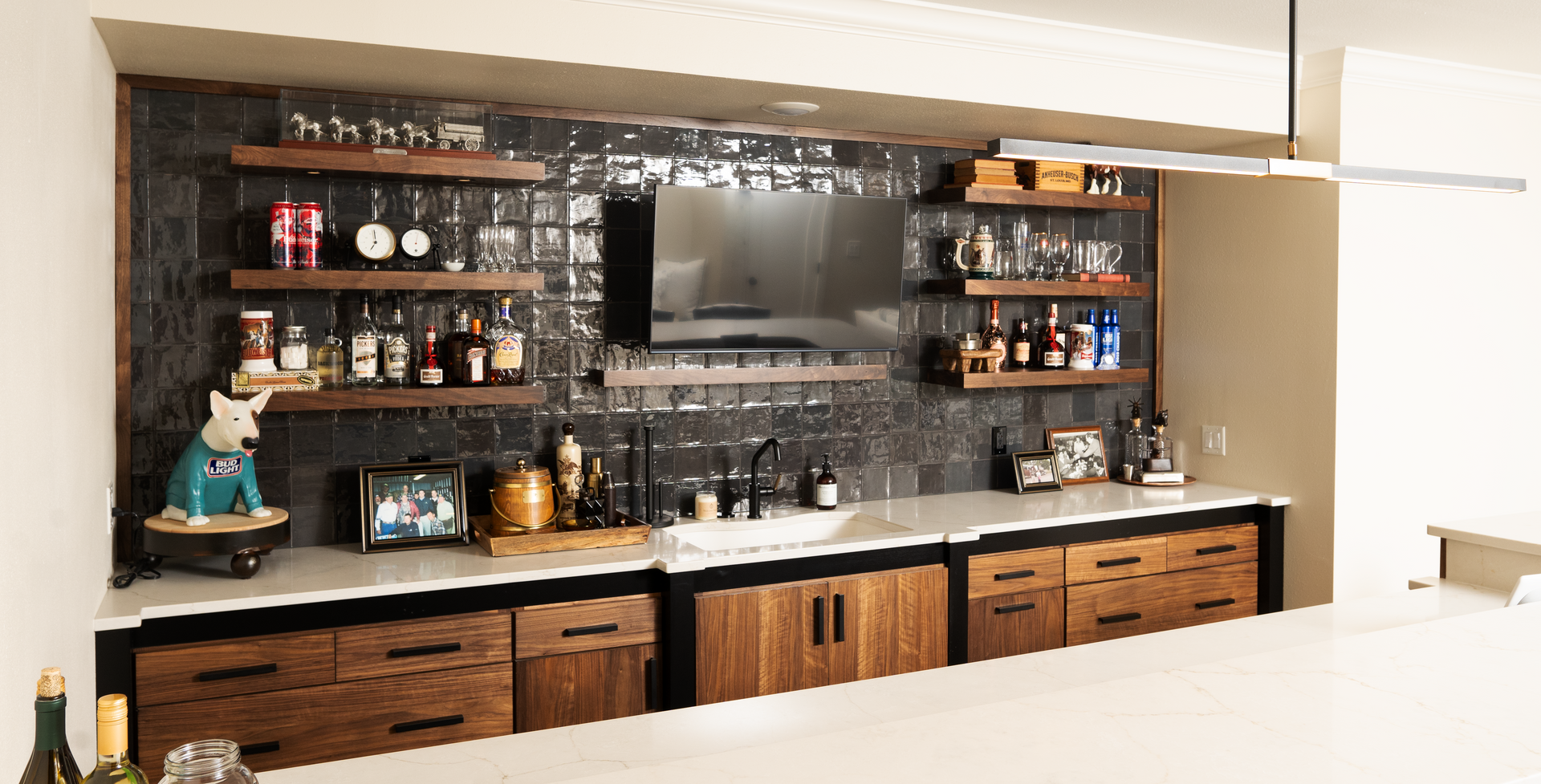 A kitchen with a bar and a television on the wall.