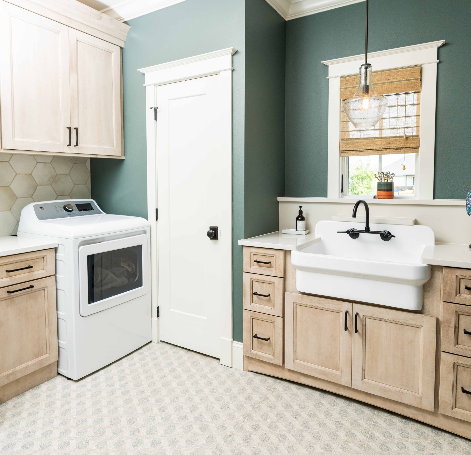 A laundry room with a washer and dryer and a sink