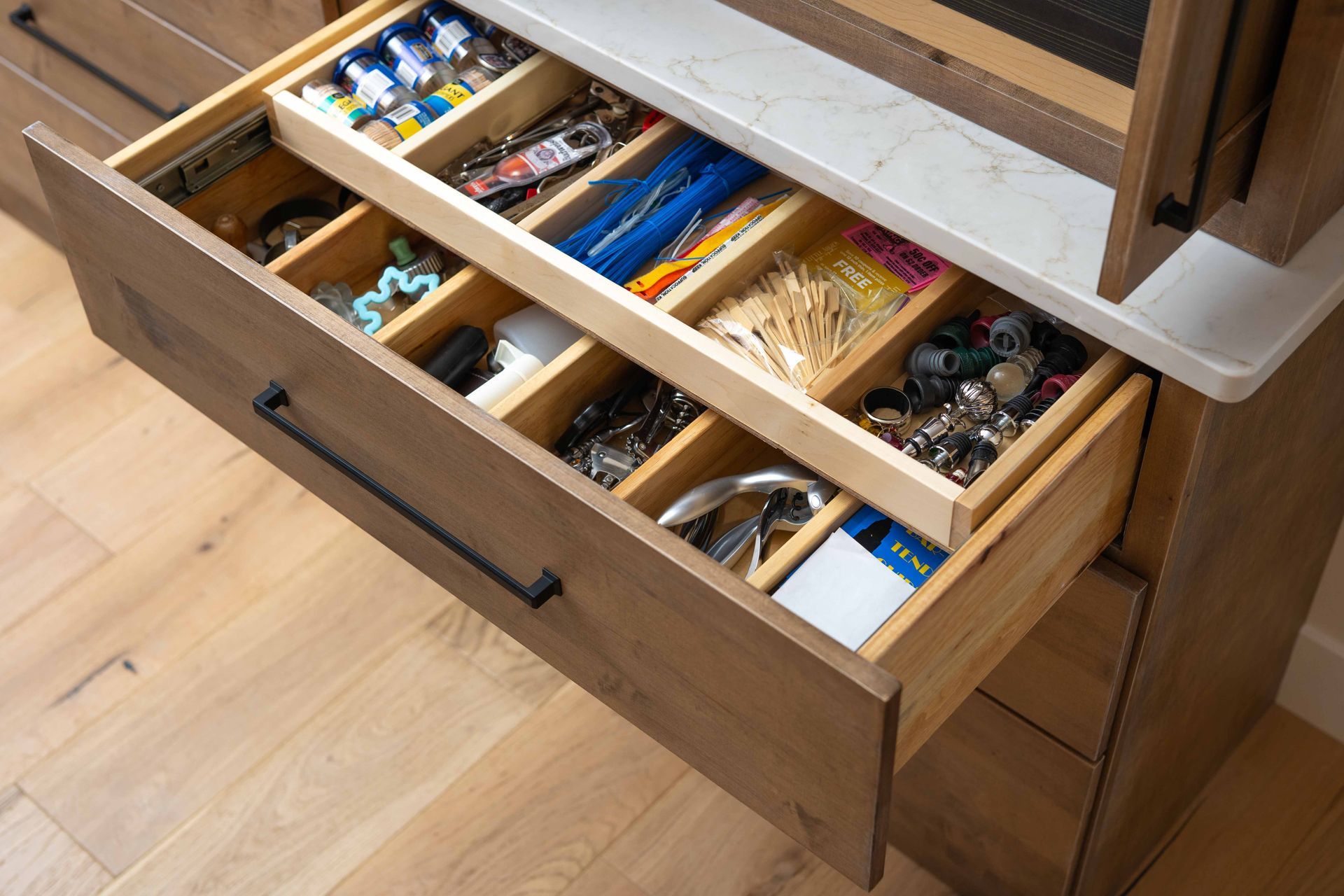 A wooden drawer filled with a variety of items.