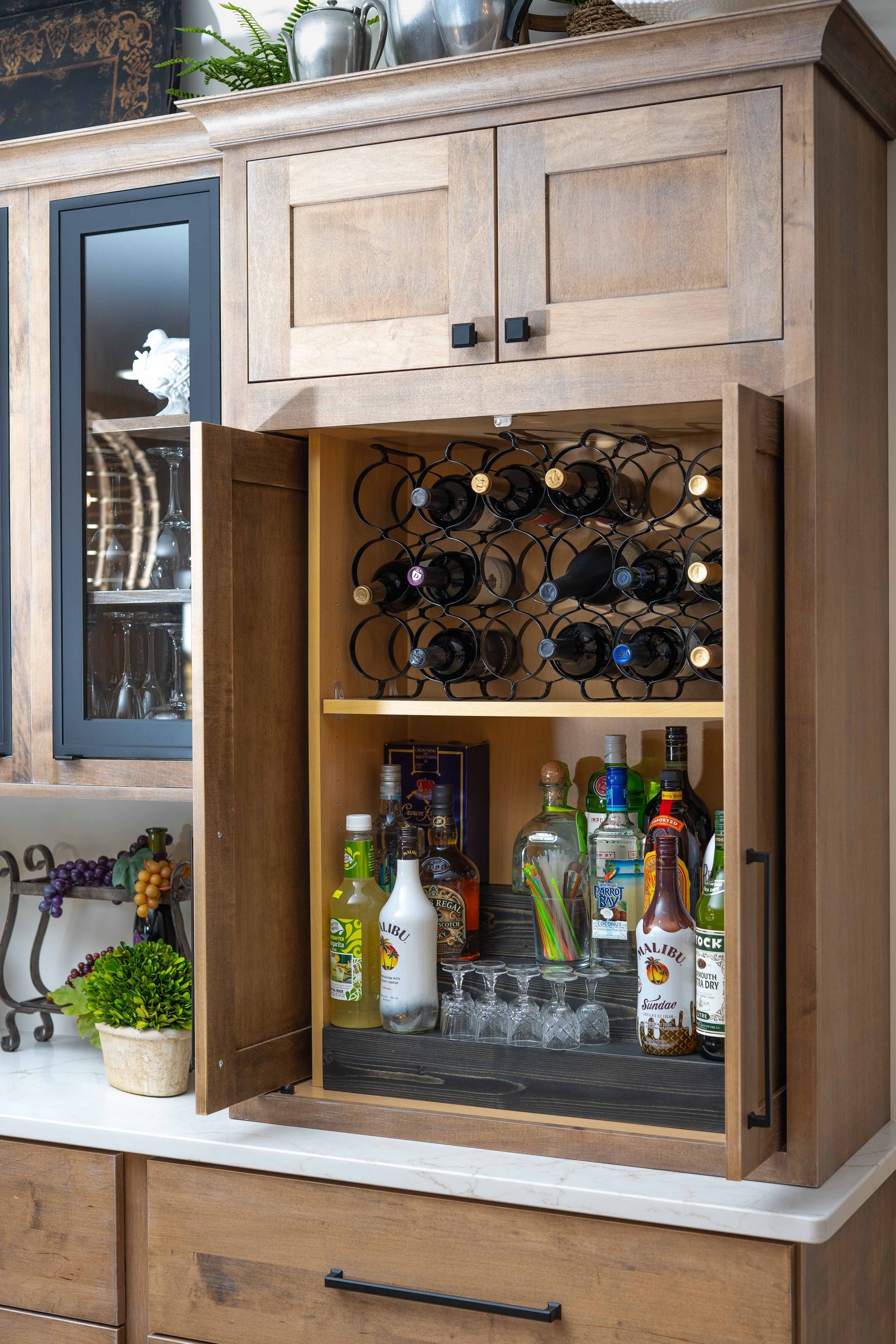 A kitchen cabinet with a wine rack and bottles in it