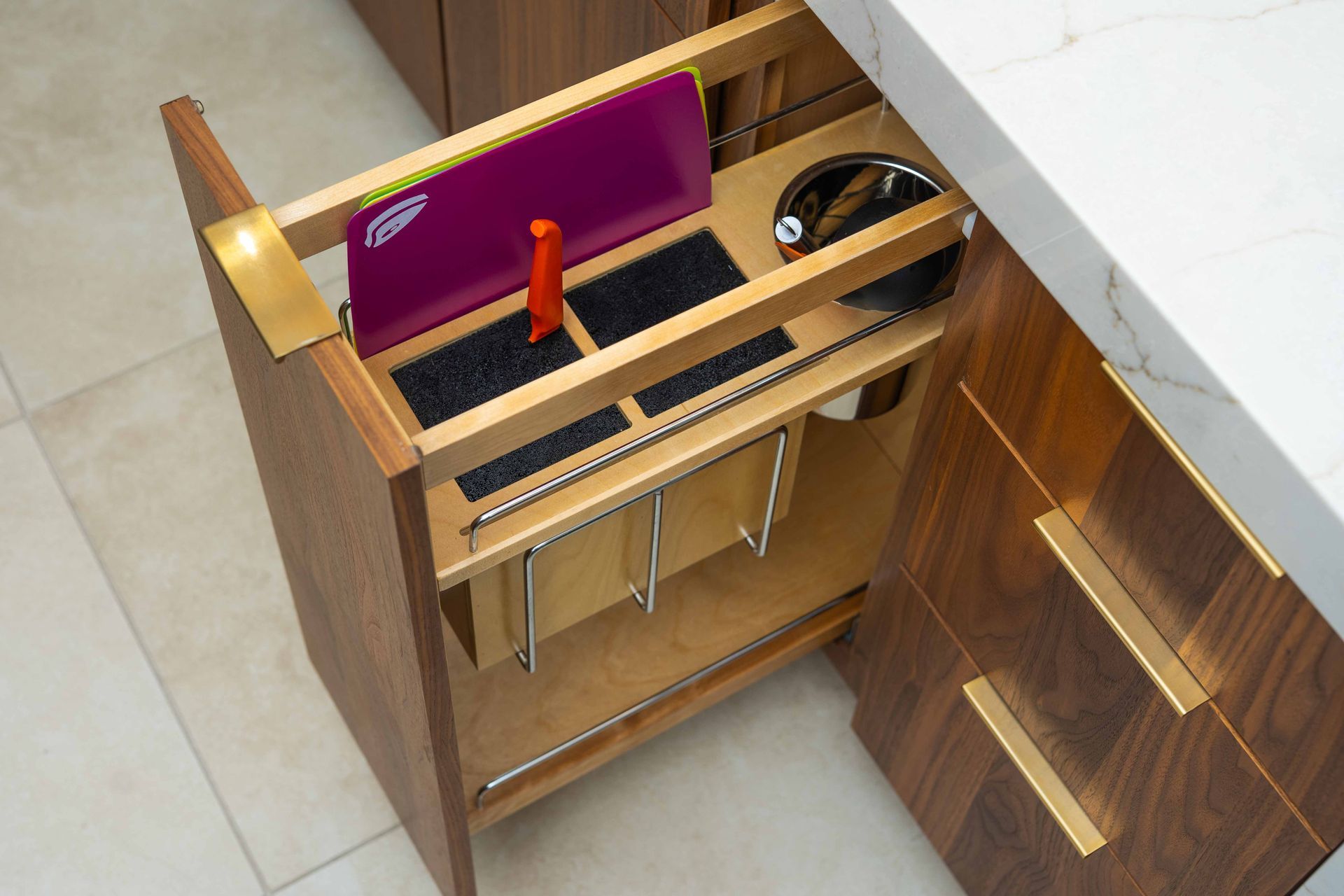 A wooden drawer in a kitchen with a purple bag on top of it.