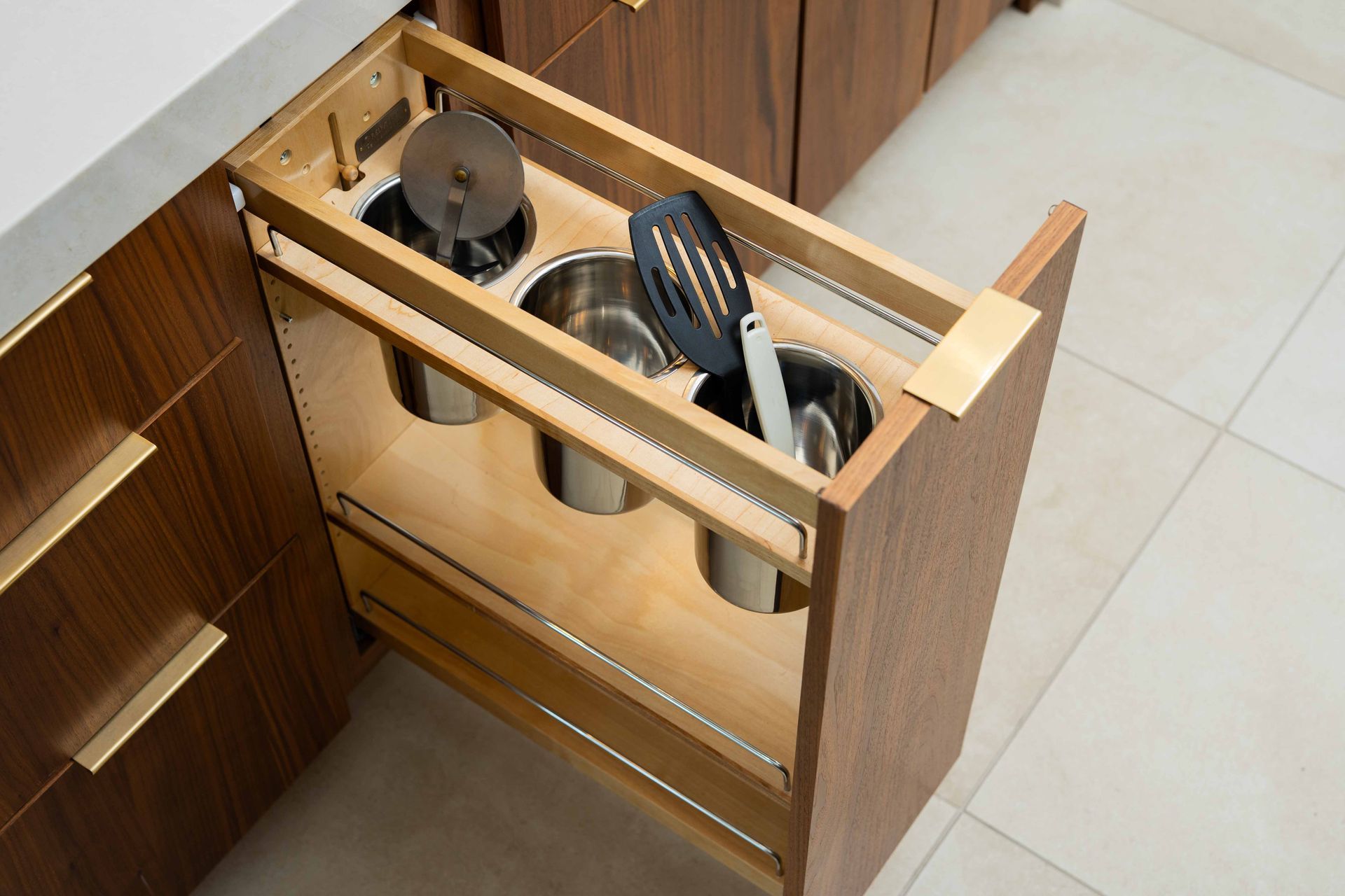 A kitchen drawer filled with pots and pans and utensils.