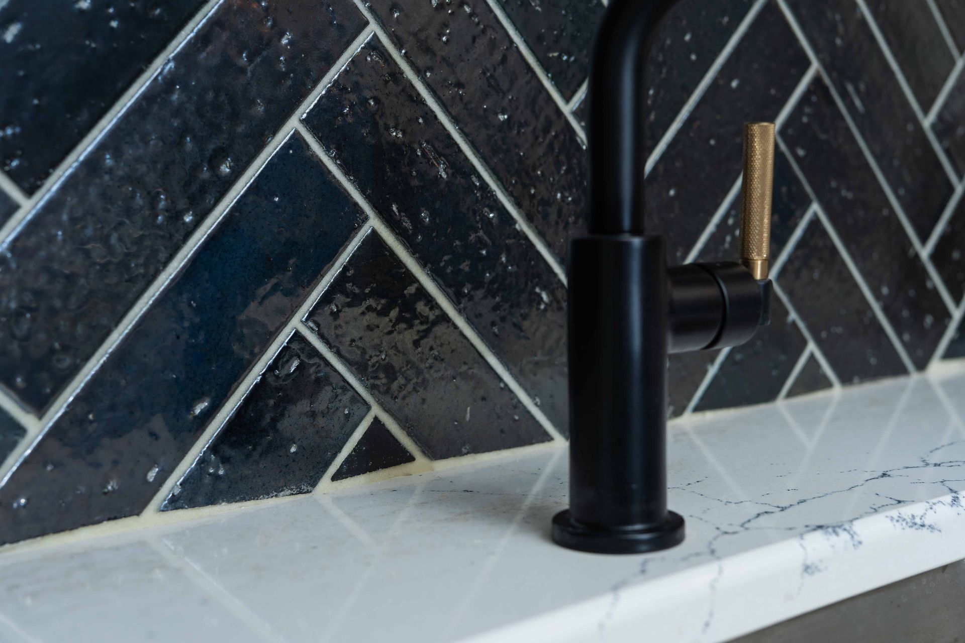 A black faucet is sitting on top of a white counter.