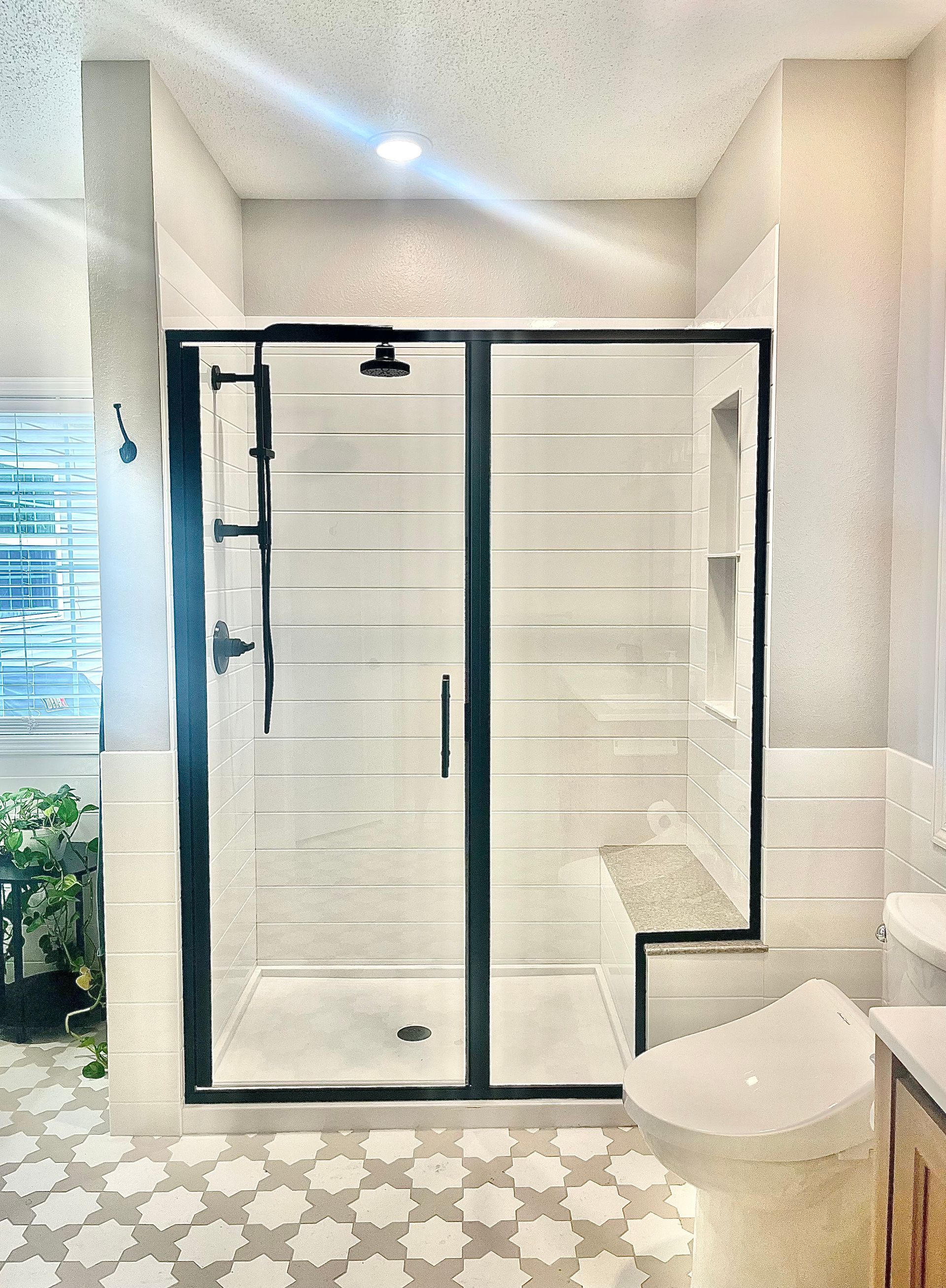 A bathroom with a walk in shower and a toilet.