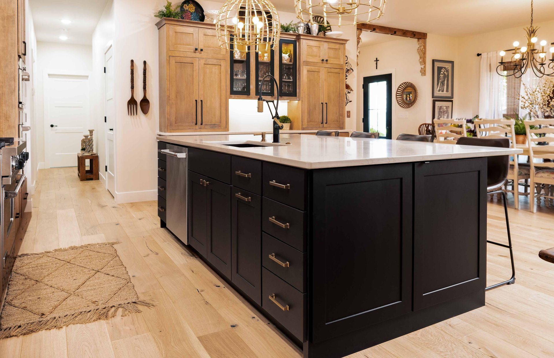 A kitchen with black cabinets and a large island in the middle.