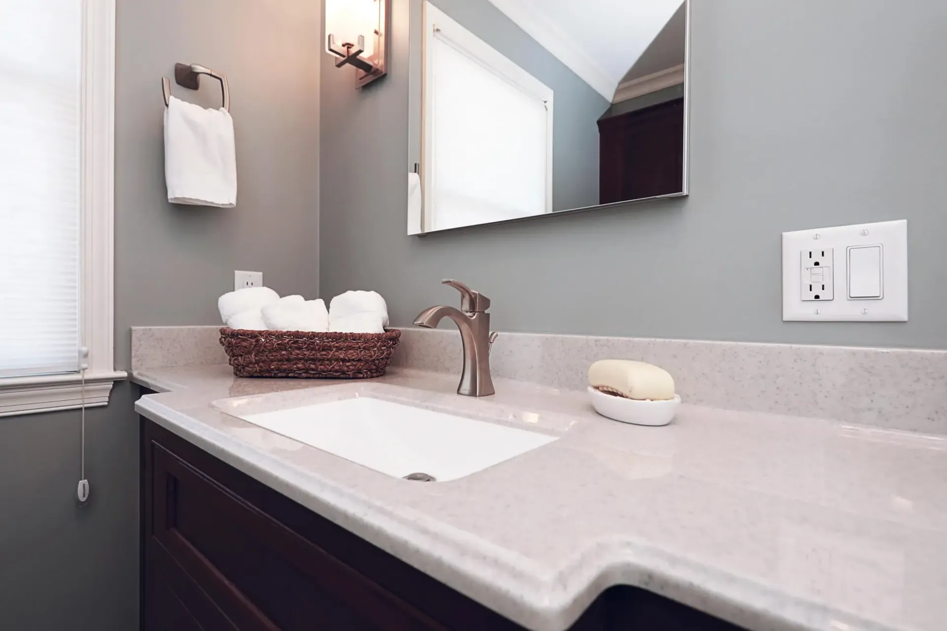 A bathroom with a sink , mirror and soap on the counter.