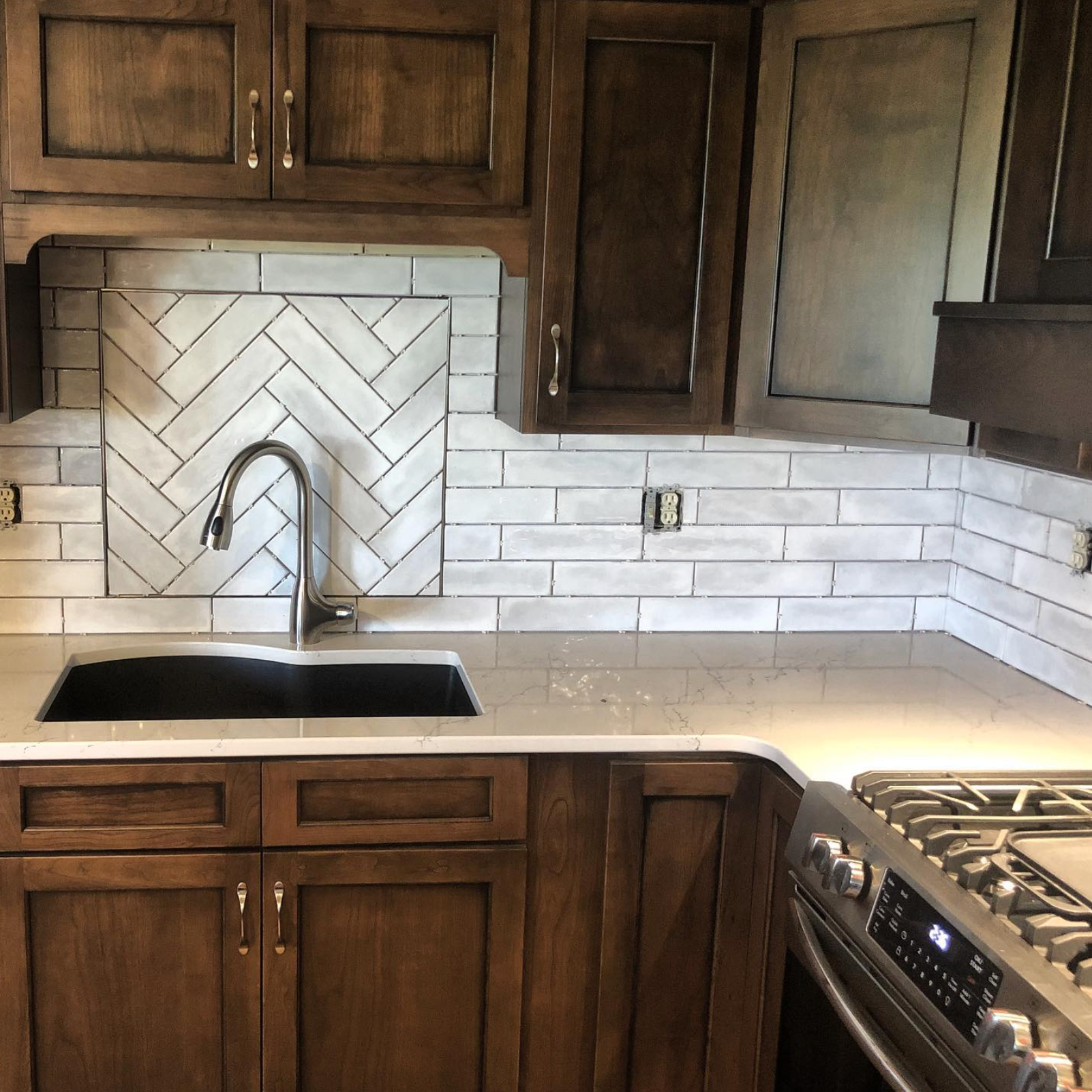 A kitchen with a stove top oven and a sink