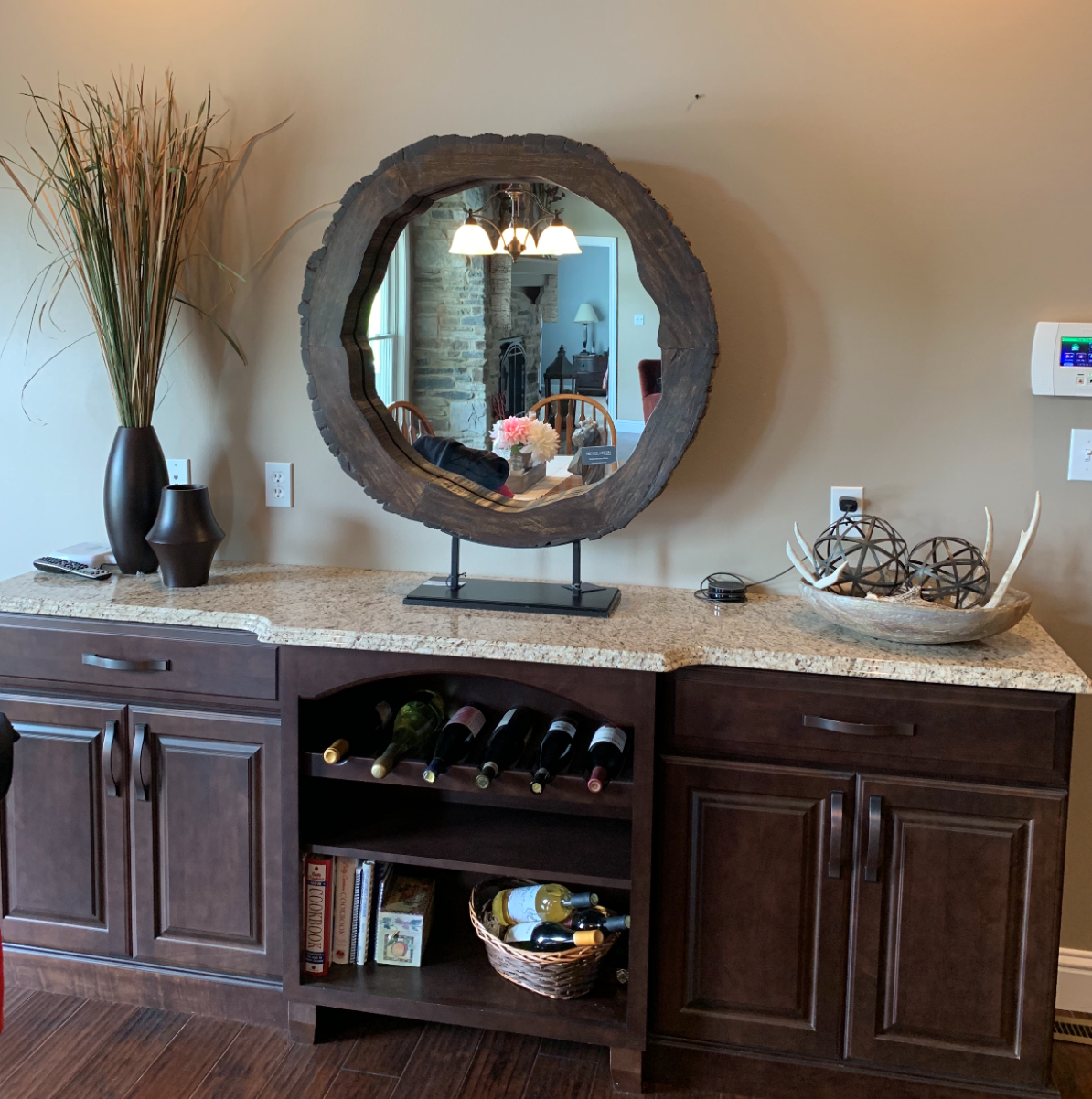 A round mirror sits on top of a counter in a living room