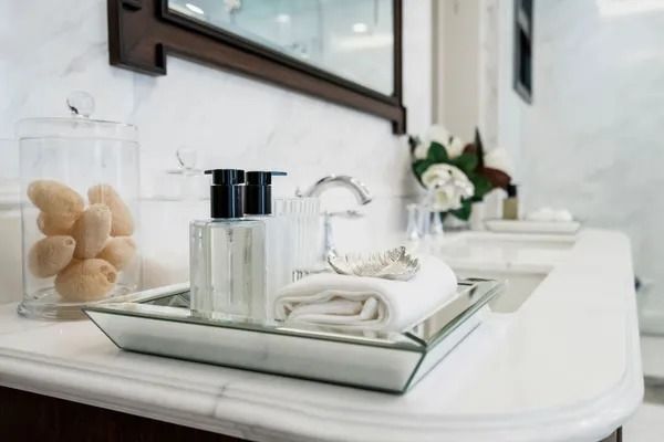 Bathroom Countertop With Tray Holding Soap Dispenser, Towel, and Clear Glass Jar — Jodi Maree Interiors in Dubbo, NSW