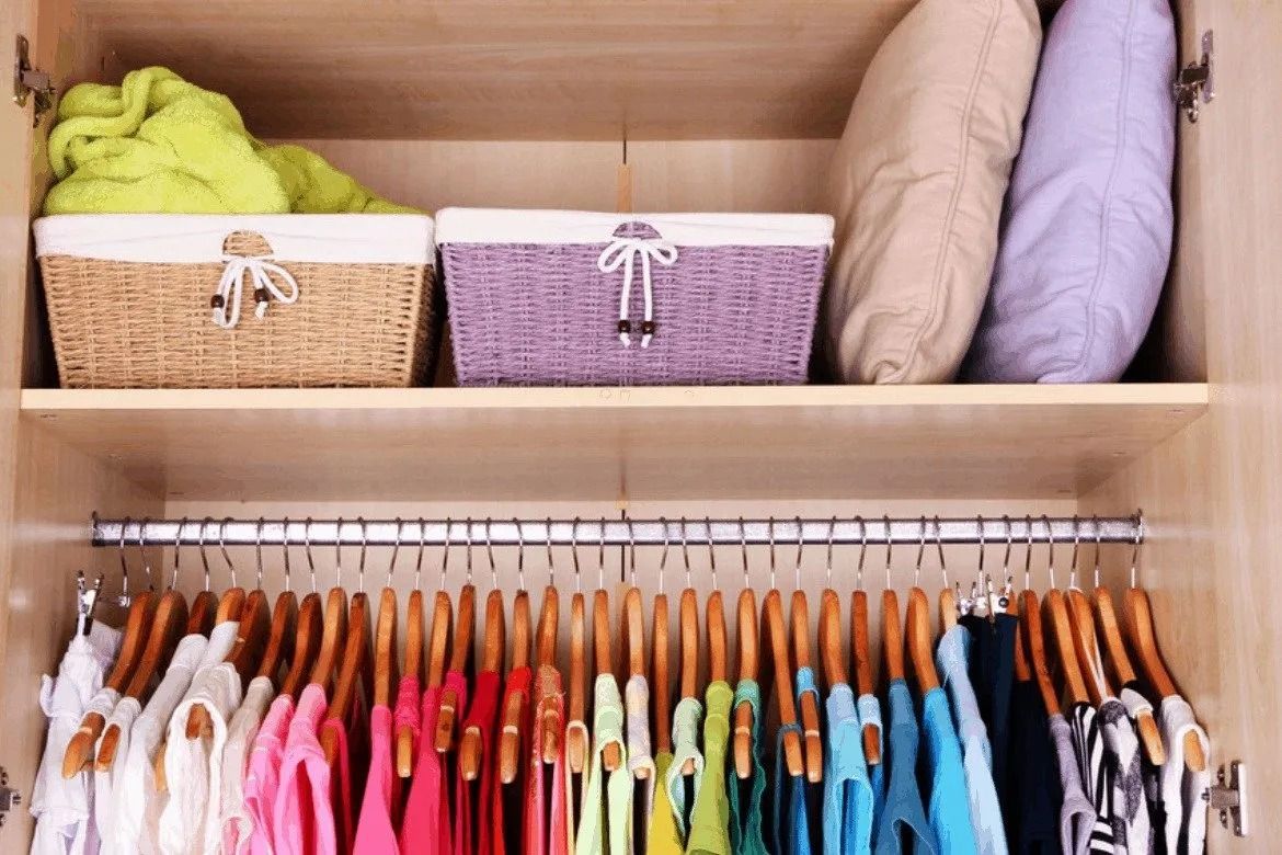 A Neatly Organized Closet With Hanging Clothes in Rainbow Order and Baskets on a Shelf Above — Jodi Maree Interiors in Dubbo, NSW