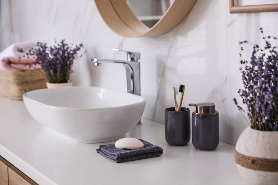 Bathroom With White Sink, Chrome Faucet, Lavender, Toiletries, and Mirror — Jodi Maree Interiors in Dubbo, NSW