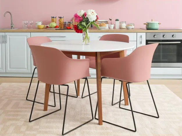 Pink Dining Chairs Around a White Round Table in a Pink Kitchen, With Flowers — Jodi Maree Interiors in Dubbo, NSW
