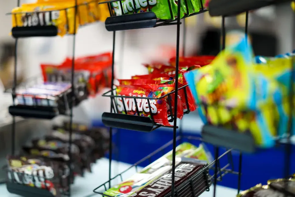 Candy display rack with various colorful wrapped candies.