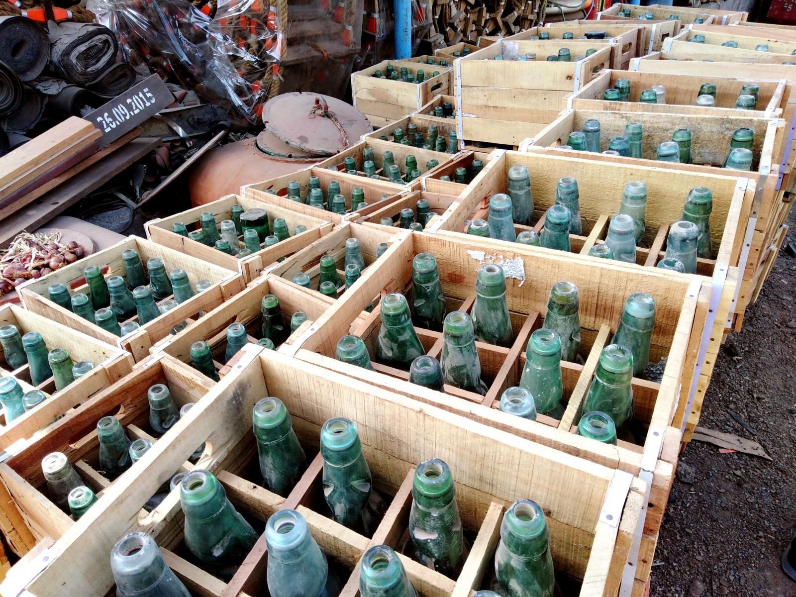 antike Bierflaschen in Holzkisten in Alang sind nicht mit dem einheimischen Pfandsystem kompatibel
