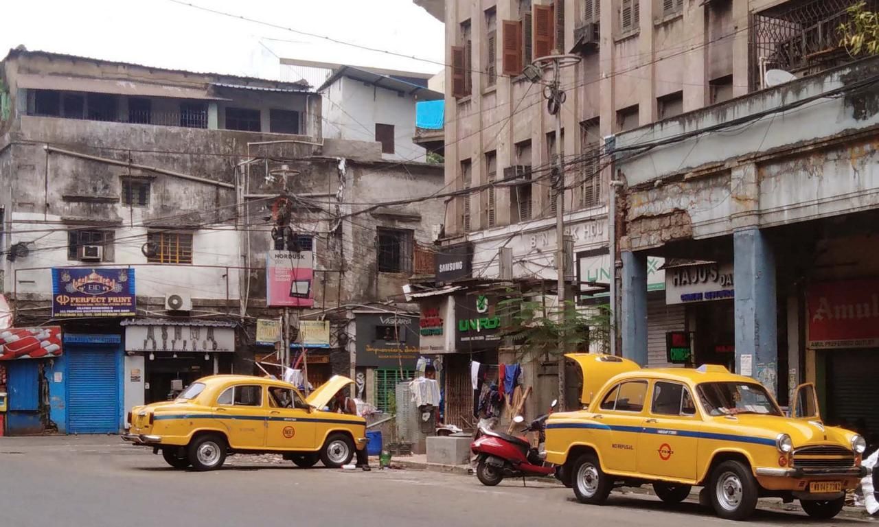 alte Taxis werden in Kalkutta am Straßenrand gereinigt