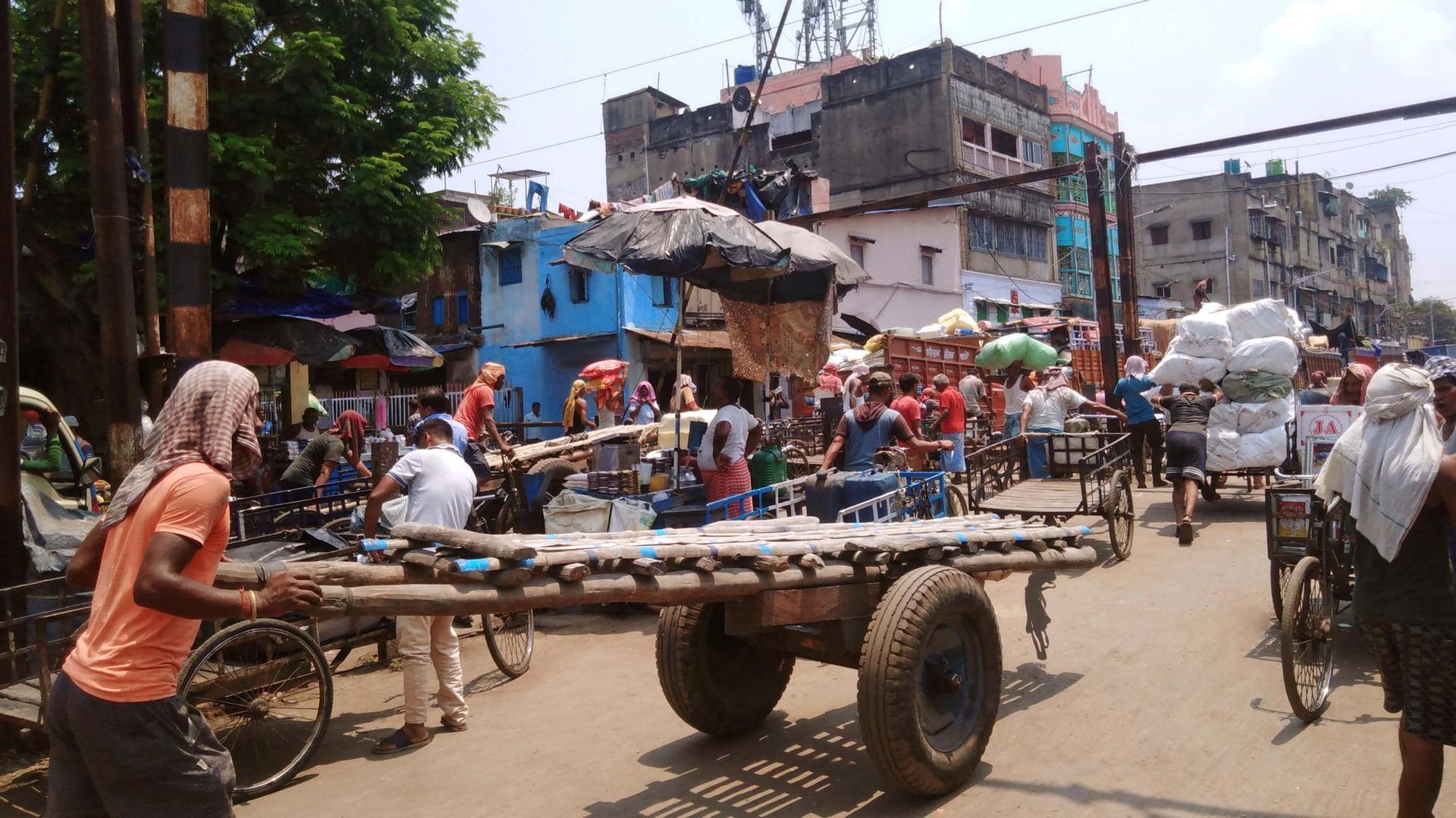 Seitenstraße in Burrabazar Kalkutta, Träger sind mit Wägen und Karren bei der Arbeit