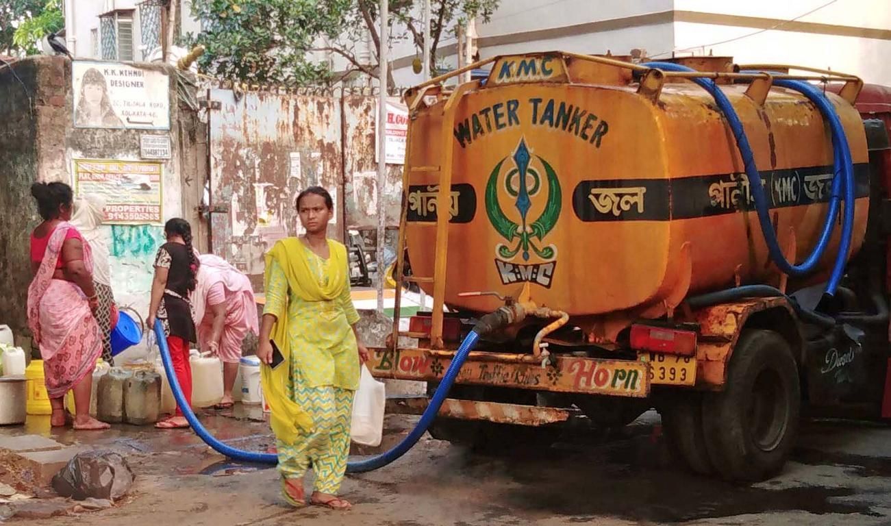 Bewohner eines Stadtviertels in Kalkutta befüllen Kanister mit Trinkwasser aus einem Tankwagen