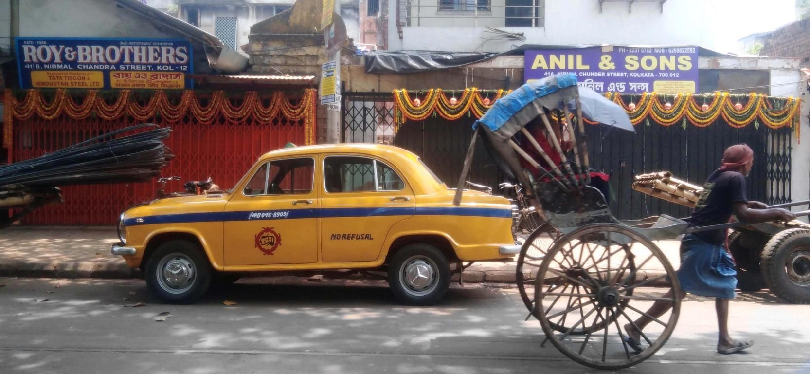 Taxi neben einem Rickscha- Zieher in Kalkutta