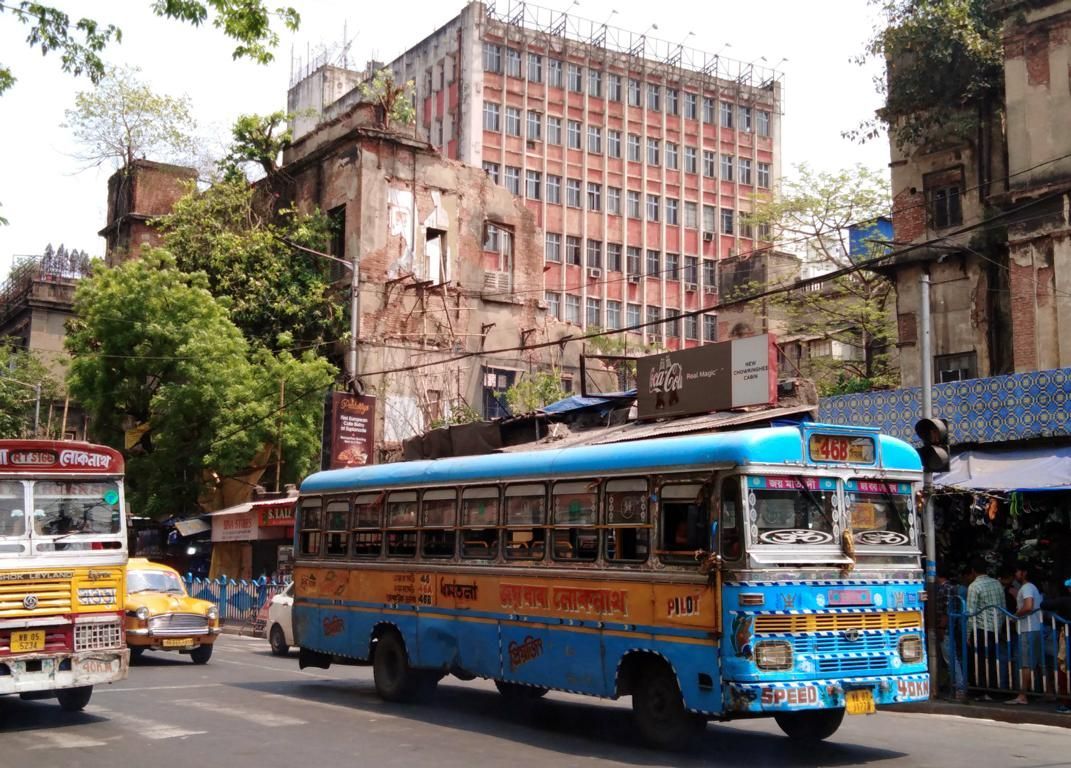Bürohaus in Kalkutta  im Stil der sozialistischen Moderne, davor ein bunter alter Bus