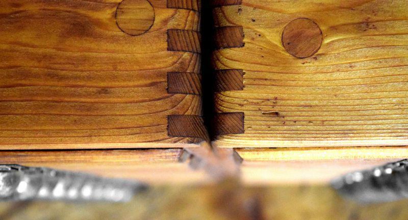 Gebrauchsspuren auf einem antiken Schubladenschrank aus Holz