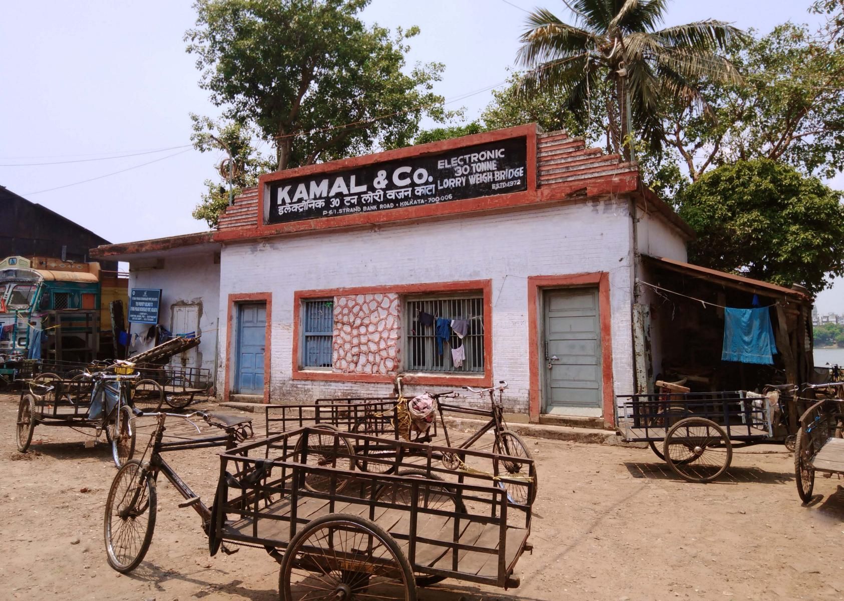 Lagerhaus am Ufer des Ganges in Kalkutta. Lastenfahrräder sind davor geparkt.