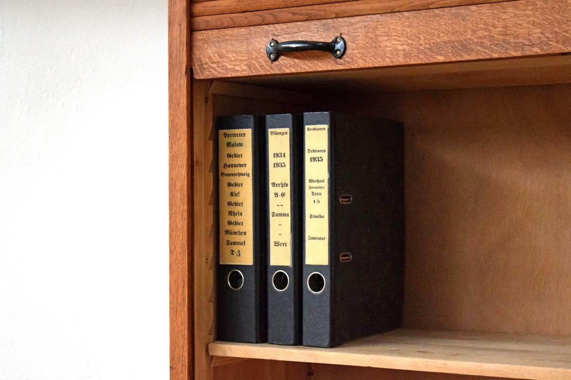 Aktendordner in einem antiken Rollladenschrank