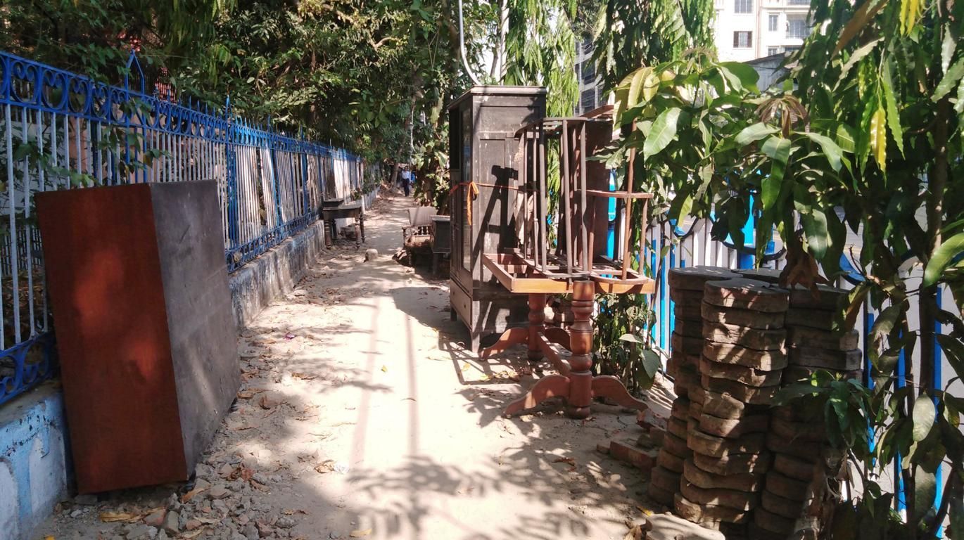 Fußweg in Kalkutta, darauf sind alte Möbel abgestellt. 