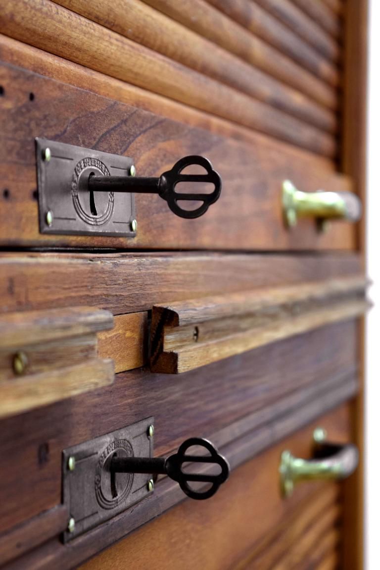 Mittelpunkt an einem antiken Rollladenschrank sind die beiden Schlösser