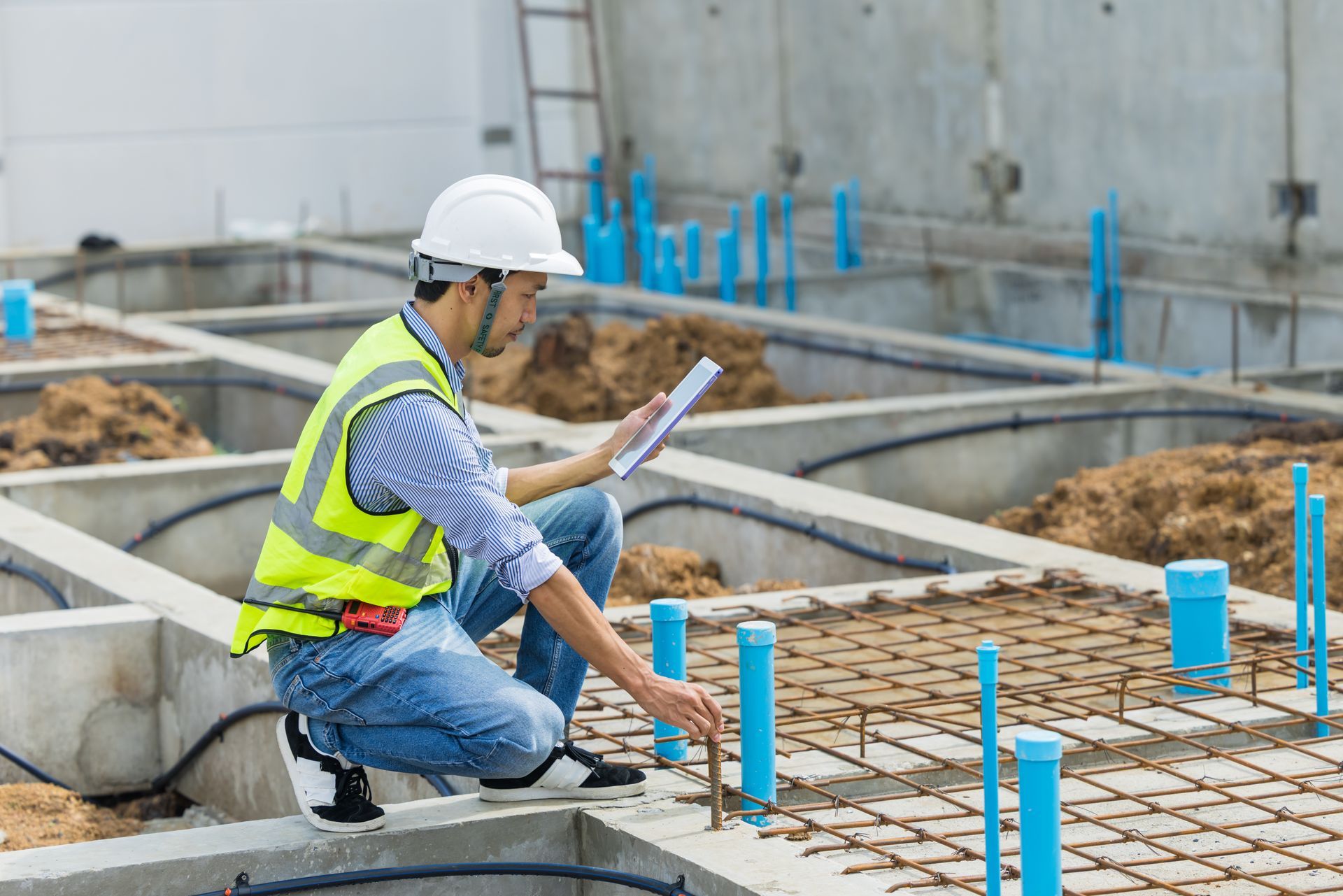 The inspector is checking rebar and layout during concrete foundation work. The inspector is checking rebar and layout during concrete foundation work.