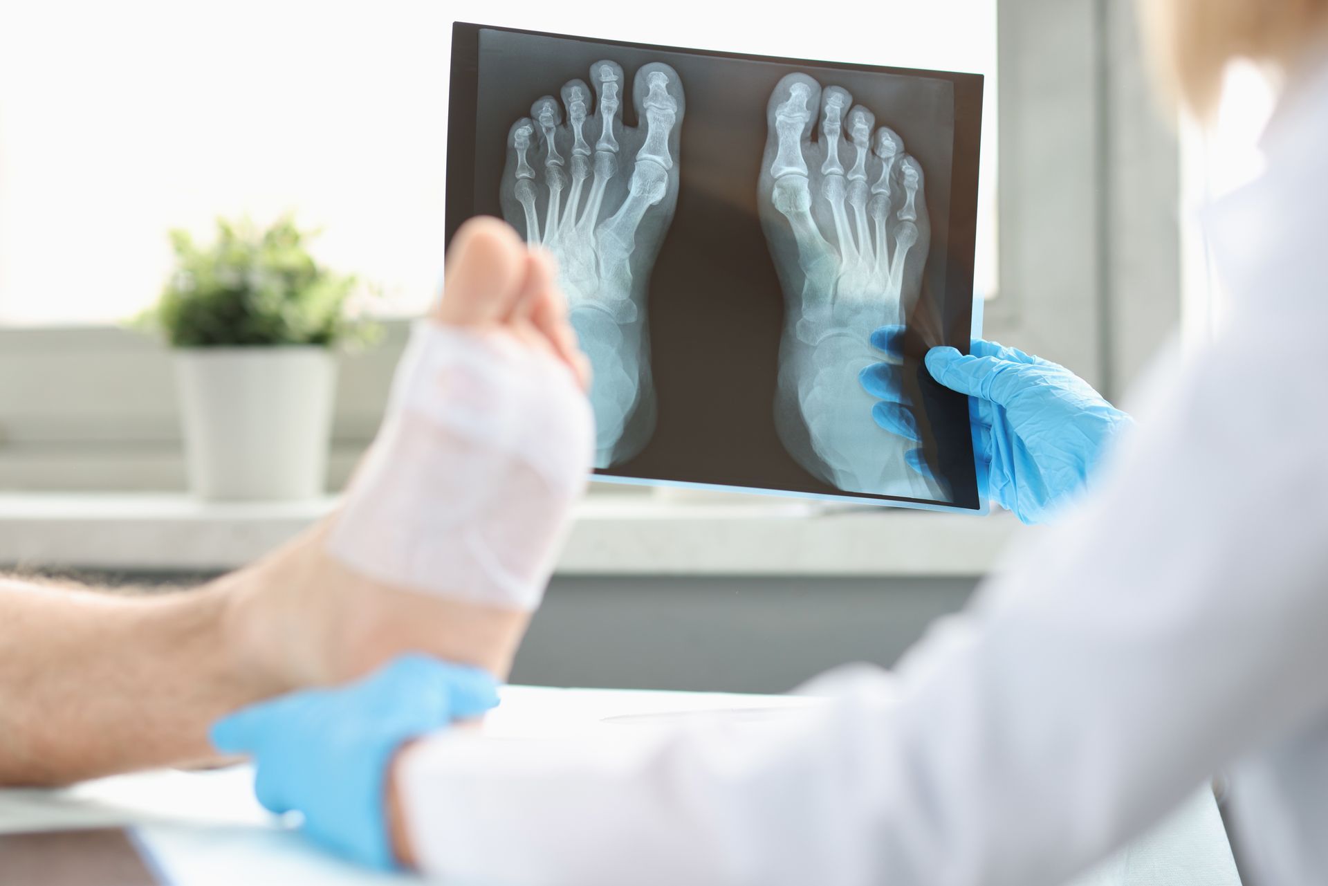 A doctor is looking at an x-ray of a patient's foot.