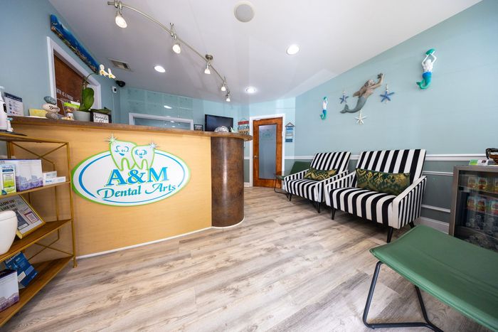 Reception area of A&M Dental Spa with a wooden desk, striped chairs, and blue walls with mermaid decor.
