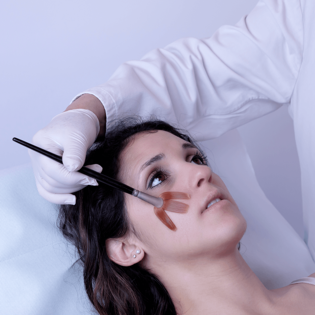 una donna è sdraiata su un letto mentre un medico applica una maschera al viso