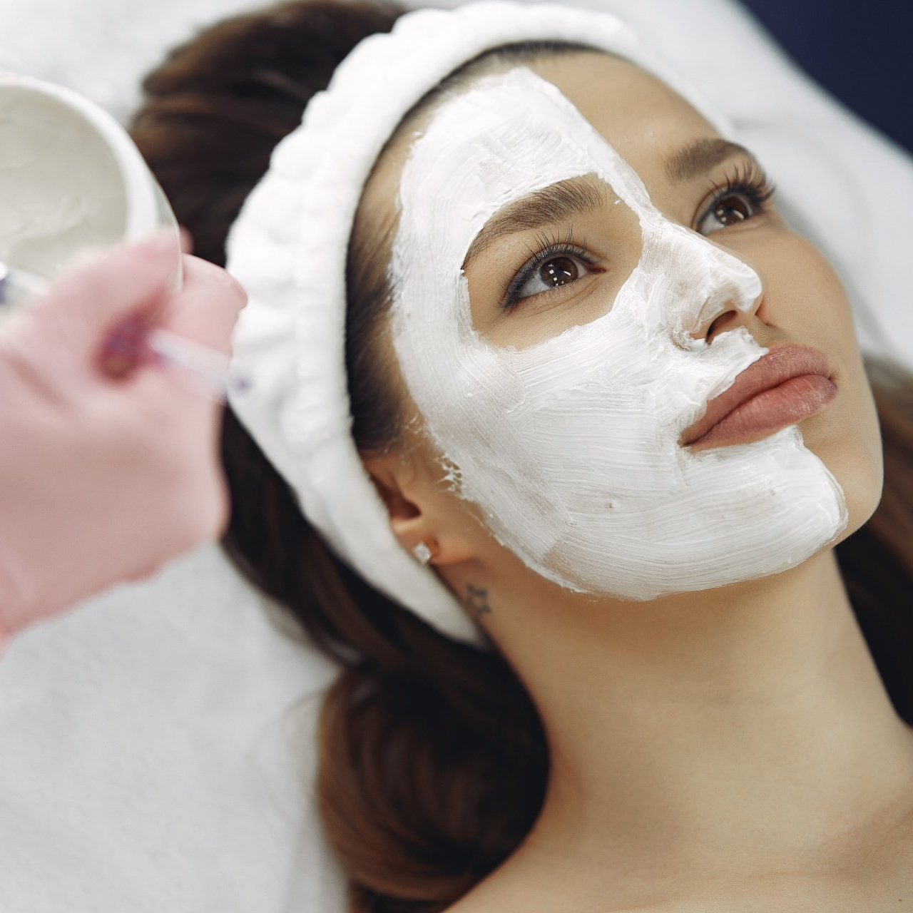 una donna riceve una maschera bianca sul viso