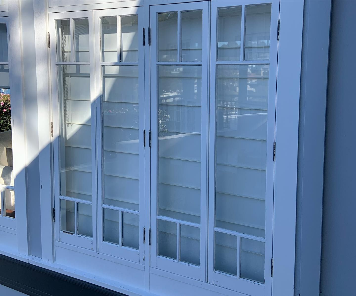 White wooden wall-mounted cabinets with glass panel doors and interior shelves.