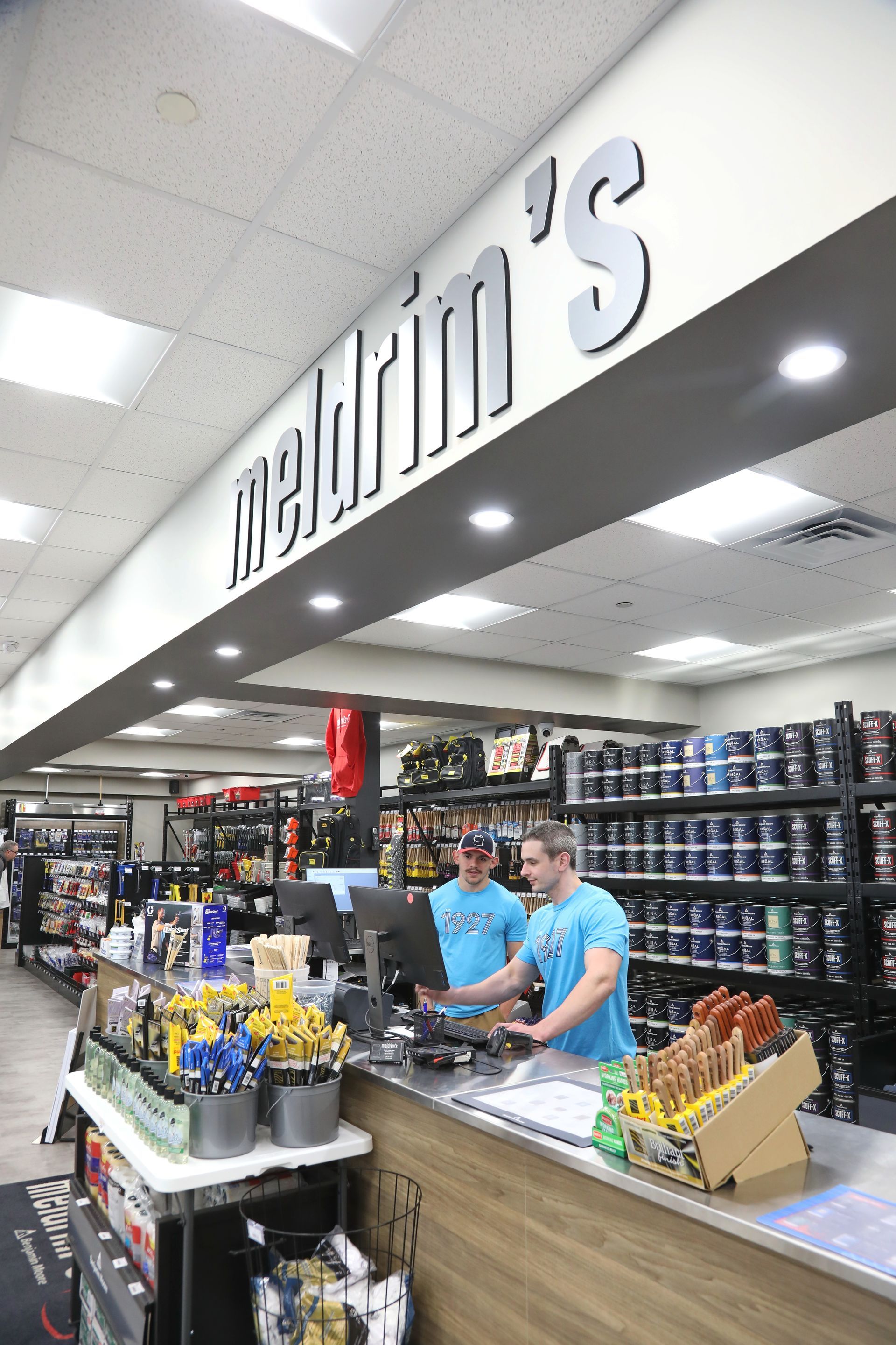 Two men are standing at a counter in a store.