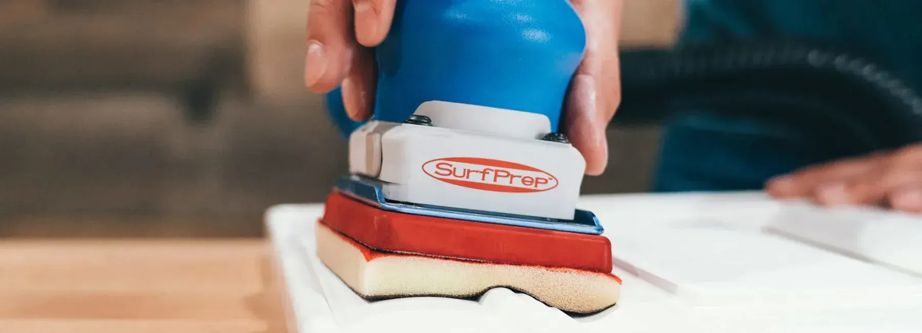 A person is using a vacuum cleaner to clean a sponge on a table.