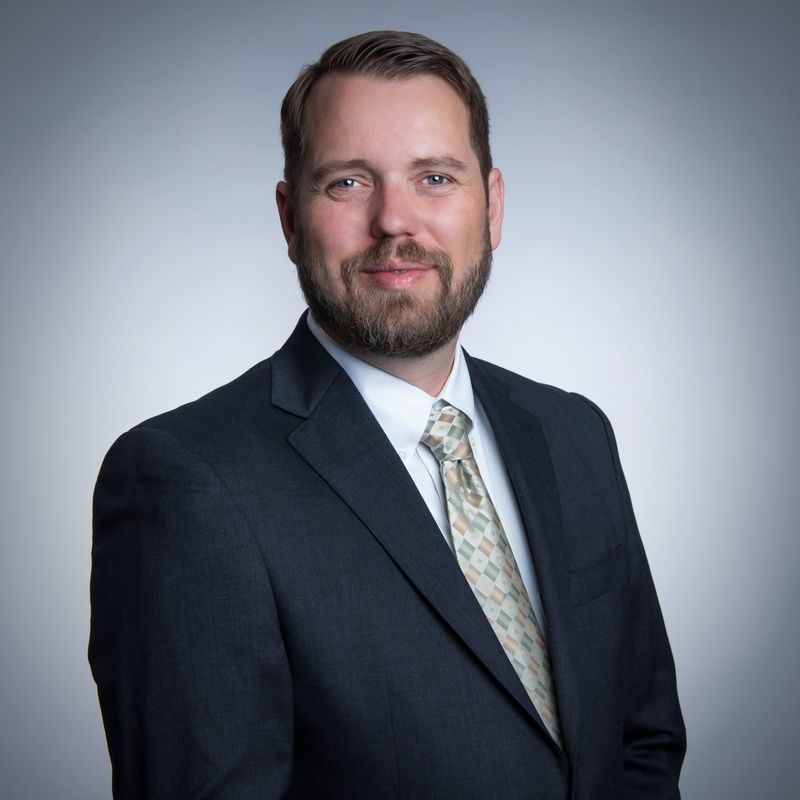 A man with a beard is wearing a suit and tie