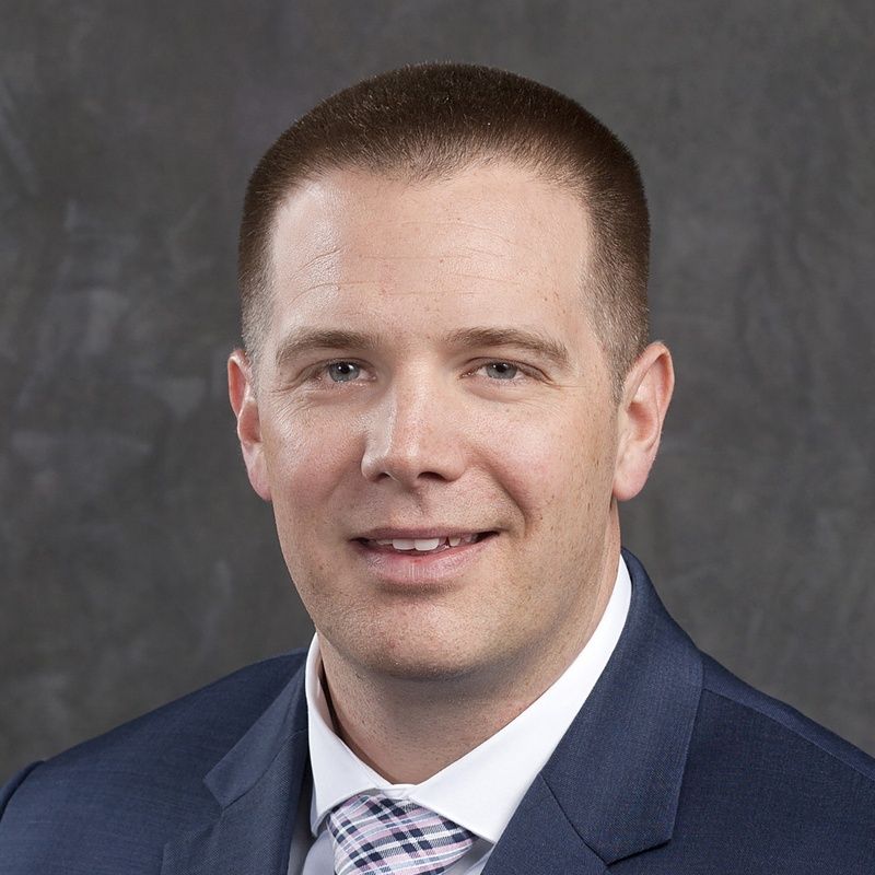 A man in a suit and tie is smiling for the camera.