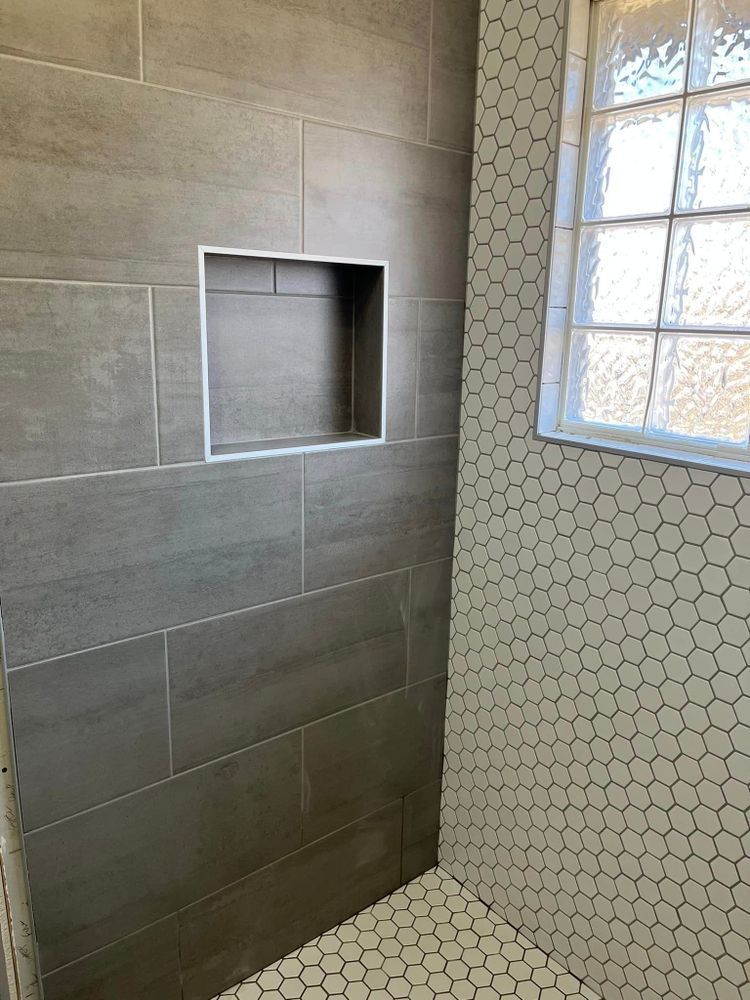 Modern tiled bathroom with a recessed wall niche and a glass block window