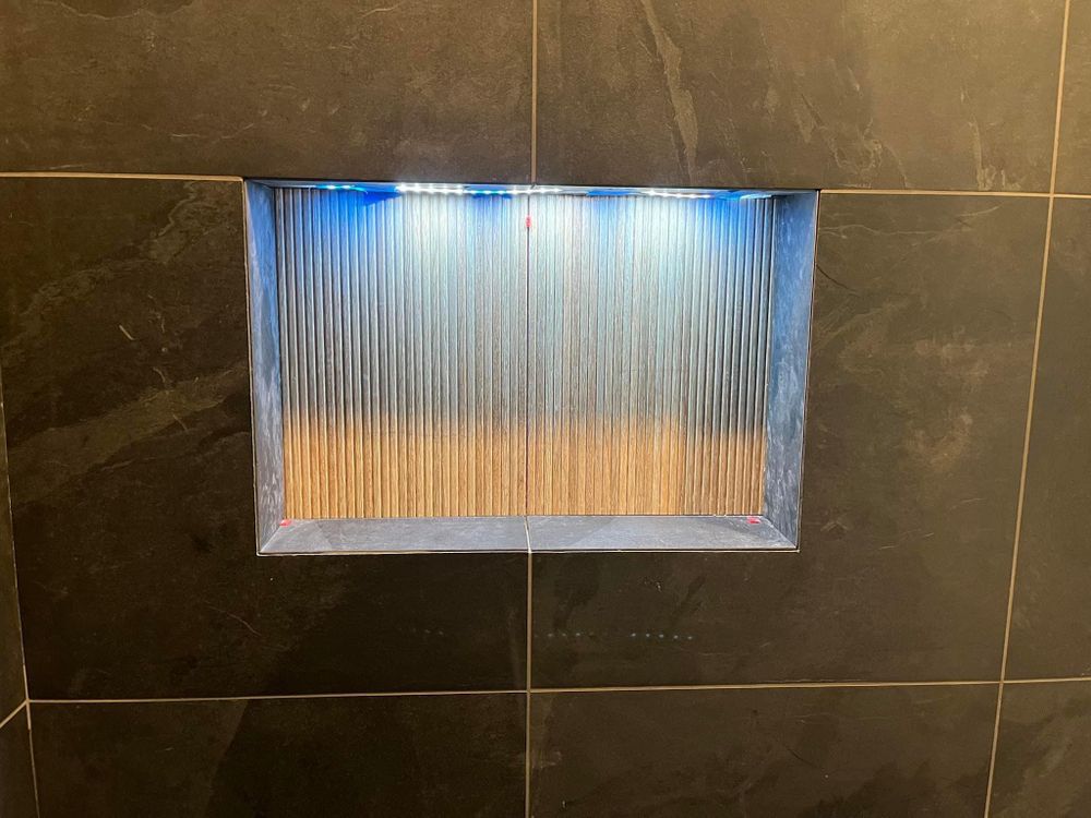 Wall niche with ribbed glass panel and blue light above an orange-toned interior