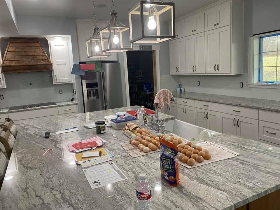 Modern kitchen island with eggs, groceries, and a marble countertop under pendant lights